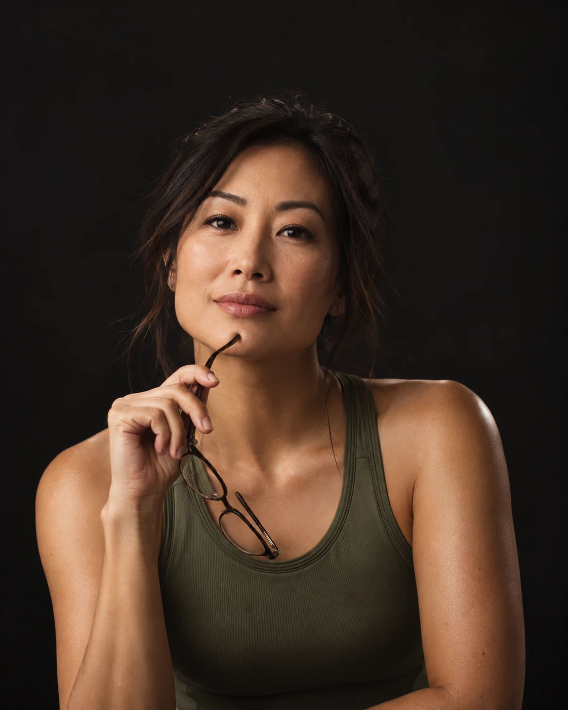 Thoughtful woman holding reading glasses